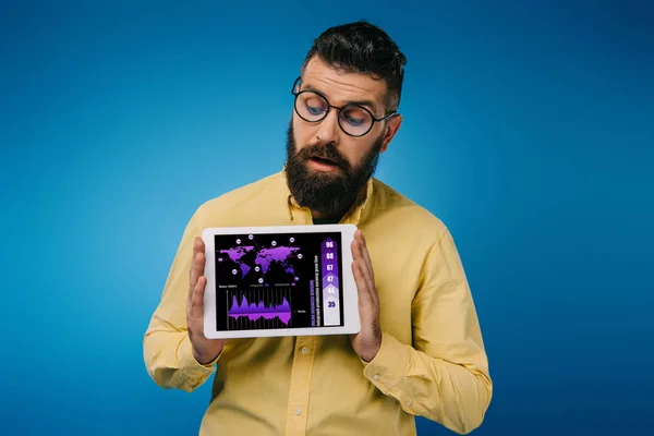 Uomo barbuto interessato guardando tablet digitale con infografica, isolato su blu — Foto stock