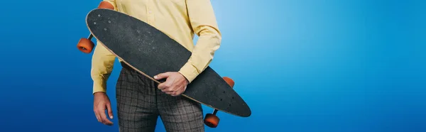 Cropped view of man holding longboard isolated on blue — Stock Photo