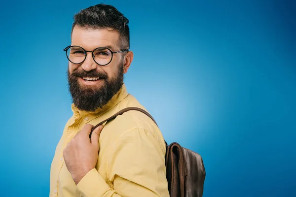 Весёлый бородатый мужчина с рюкзаком, изолированный на голубом — стоковое фото