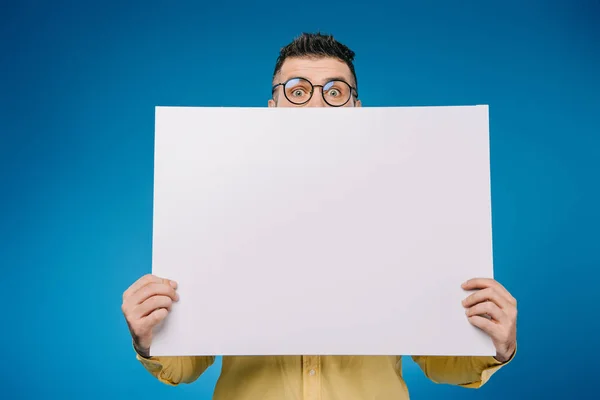 Handsome man holding blank placard isolated on blue — Stock Photo