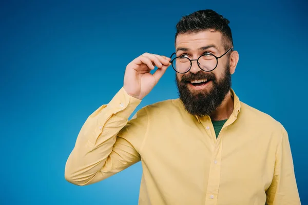 Smiling handsome man in eyeglasses isolated on blue — Stock Photo