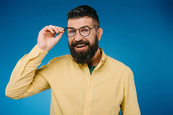 Hombre barbudo feliz en gafas aisladas en azul - foto de stock