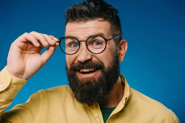 Усміхнений бородатий чоловік в окулярах ізольований на синьому — стокове фото