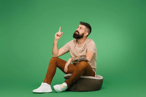 Bonito homem ter ideia e apontando para cima no verde — Fotografia de Stock