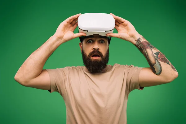 Shocked bearded man with Virtual reality headset isolated on green — Stock Photo