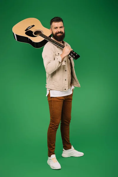 Schöner Gitarrist mit Akustikgitarre, isoliert auf Grün — Stockfoto