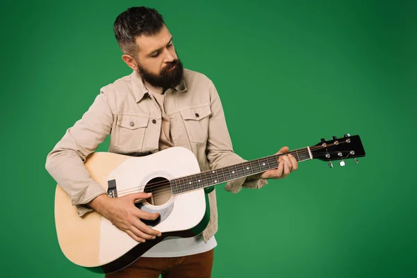 Schöner bärtiger Mann spielt auf Akustikgitarre, isoliert auf Grün — Stockfoto