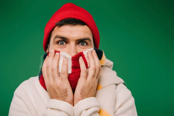 Homme barbu effrayé dans le chapeau et l'écharpe isolé sur vert — Photo de stock