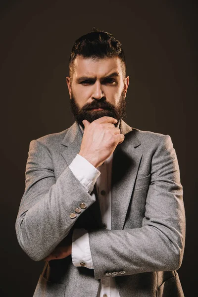 Handsome beard businessman thinking and looking at camera isolated on brown — Stock Photo