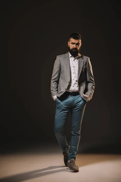 Handsome beard businessman posing in jacket on brown — Stock Photo