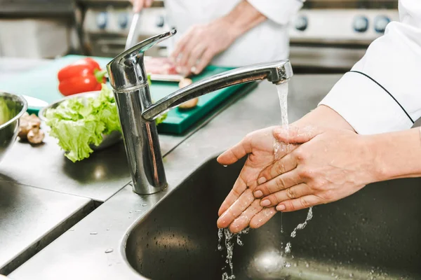 Ausgeschnittener Blick auf Köchin beim Händewaschen über Spüle in Restaurantküche — Stockfoto