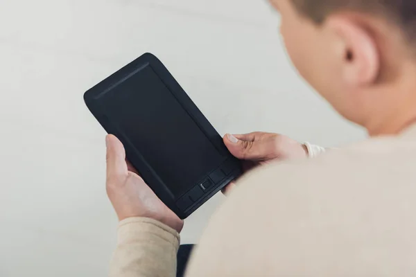 Selective focus of man holding ebook with blank screen — Stock Photo