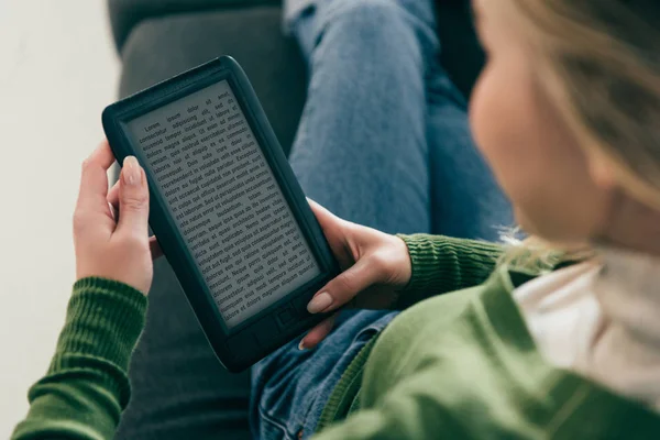 Selective focus of woman studing with ebook while sitting on sofa — Stock Photo