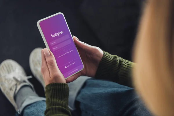 Cropped view of woman holding smartphone with instagram app on screen — Stock Photo