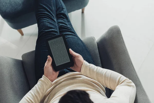 Vista dall'alto dell'ebook di lettura dell'uomo a casa — Foto stock