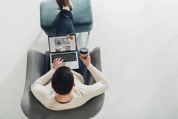 Top view of man using laptop with bbc website on screen — Stock Photo