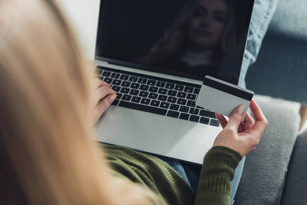 Messa a fuoco selettiva della donna che utilizza il computer portatile con schermo bianco mentre detiene la carta di credito — Foto stock