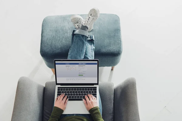 Cropped view of woman using laptop with facebook website on screen — Stock Photo