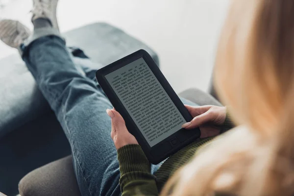 Abgeschnittene Ansicht einer Frau, die zu Hause ein Buch liest — Stockfoto