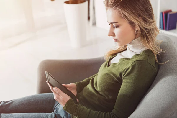 Beautiful woman holding e-book and studing at home — Stock Photo