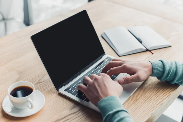 Vista cortada de homem digitando no laptop com tela em branco enquanto trabalhava em casa — Fotografia de Stock