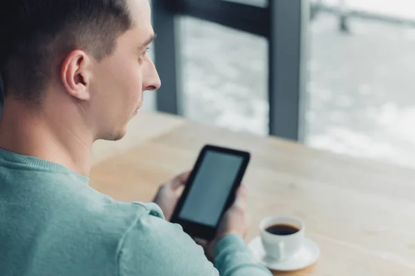 Selective focus of man studing with e-book near cup with tea — Stock Photo