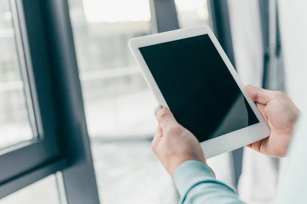Vista recortada del hombre sosteniendo tableta digital con pantalla en blanco en las manos — Stock Photo