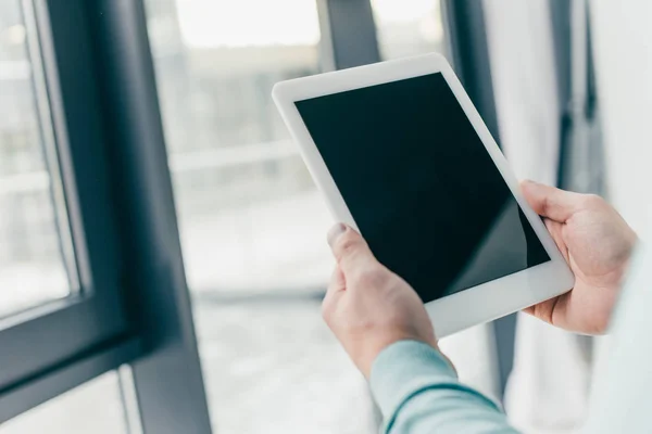 Vista ritagliata di uomo che tiene tablet digitale con schermo vuoto in mano — Foto stock