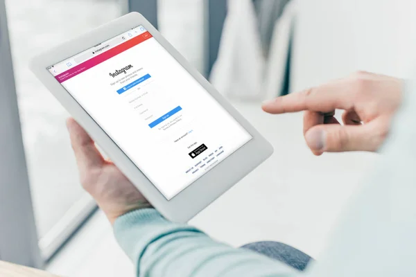 Vista ritagliata dell'uomo con tablet digitale con app instagram sullo schermo — Foto stock