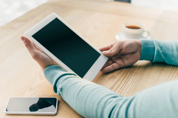 Cropped view of man holding digital tablet with blank screen near smartphone — Stock Photo