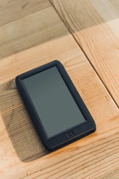 Ebook avec écran blanc couché sur une table en bois — Photo de stock