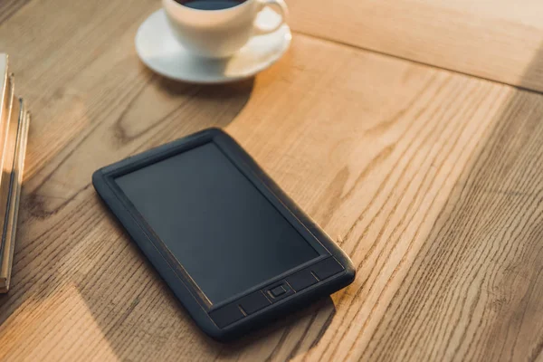 E-book avec écran blanc couché près de tasse avec café — Photo de stock