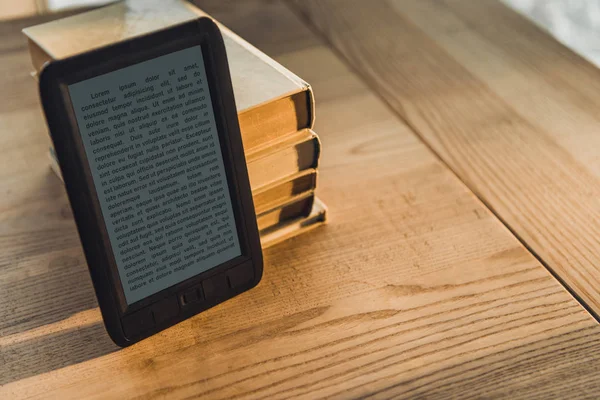 Чорний ebook поблизу паперових книг на дерев'яні таблиці — стокове фото