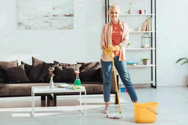 Smiling senior woman posing with mop and bucket — Stock Photo