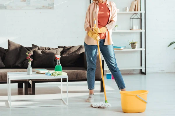 Обрізаний вид жінки прибирання будинку з мопедом і відром — стокове фото