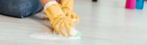 Cropped view of woman in yellow rubber gloves cleaning floor with rag — Stock Photo