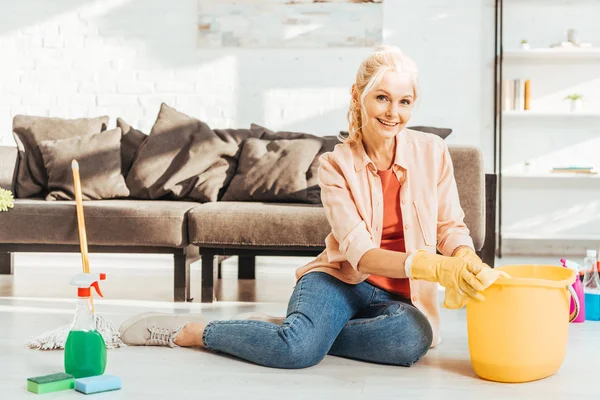 Joyeuse femme âgée en gants de caoutchouc nettoyage plancher — Photo de stock