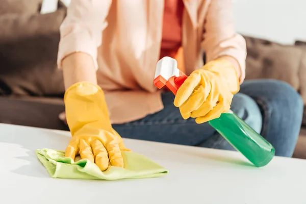 Vue recadrée de la femme en gants de caoutchouc jaune table de nettoyage — Photo de stock