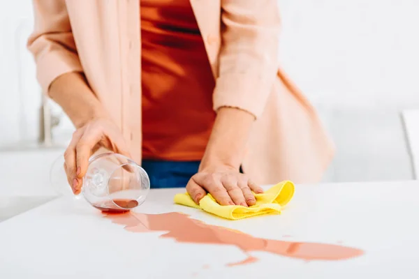 Plan recadré de la femme tenant le verre de vin et essuyant tache avec chiffon — Photo de stock