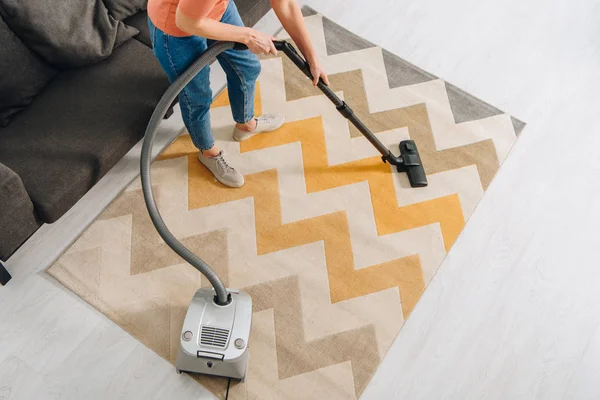 Vue recadrée de la femme nettoyage tapis avec aspirateur — Photo de stock