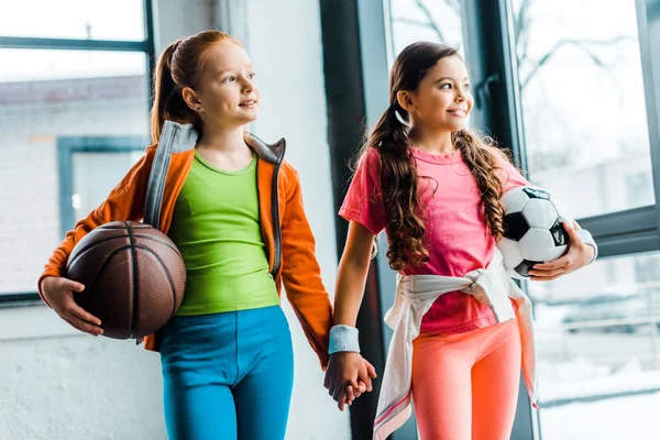 Glückselige Kinder halten Händchen, während sie in der Turnhalle posieren — Stockfoto