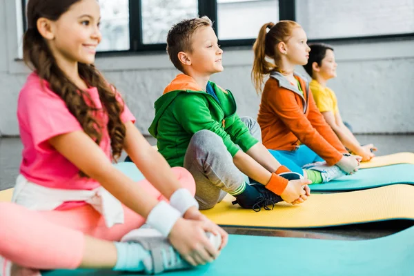 Niños preadolescentes haciendo ejercicios en colchonetas de fitness — Stock Photo