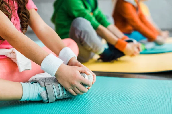 Vista cortada de crianças se alongando em tapetes de fitness — Fotografia de Stock