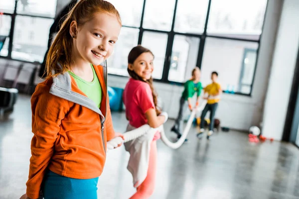 Cheerful kids playing tug of war together — Stock Photo