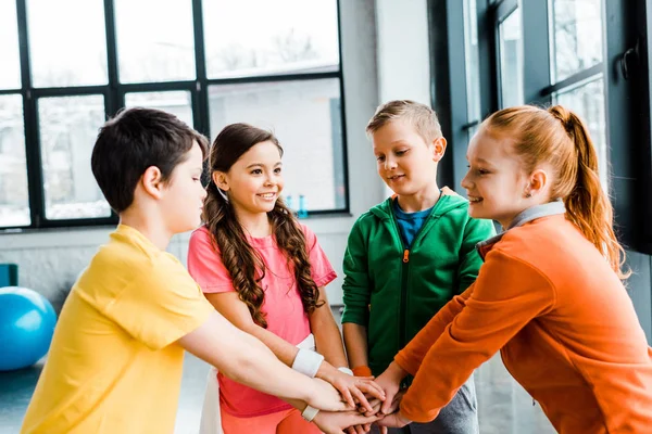 Група щасливих дітей тримає руки в тренажерному залі — стокове фото