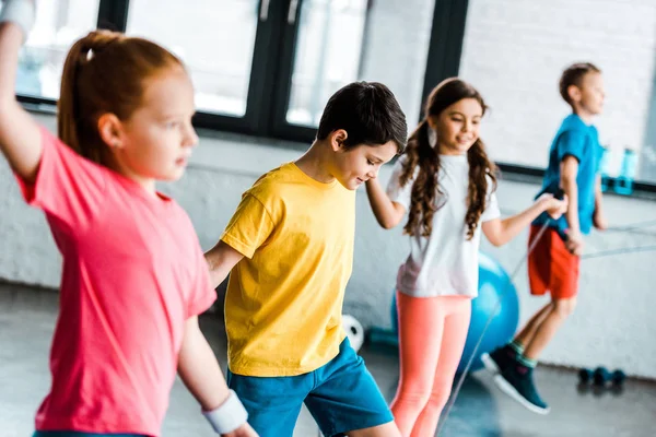 Preteen enfants sautant avec des cordes à sauter dans la salle de gym — Photo de stock