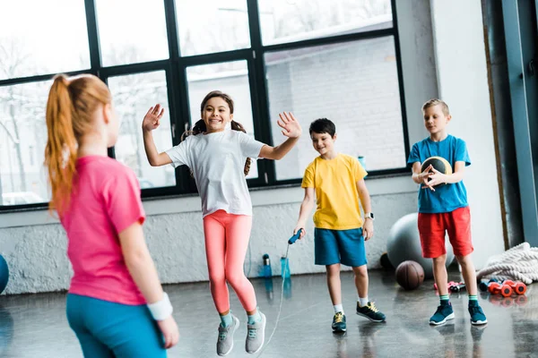 Niños inspirados saltando con la cuerda en el gimnasio - foto de stock