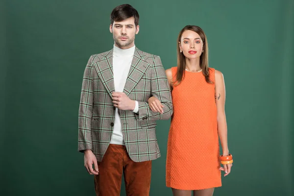 Beau couple en vêtements vintage posant isolé sur vert — Photo de stock
