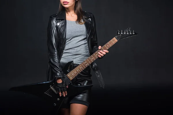 Vista cortada de mulher em jaqueta de couro com guitarra elétrica isolada em preto — Fotografia de Stock