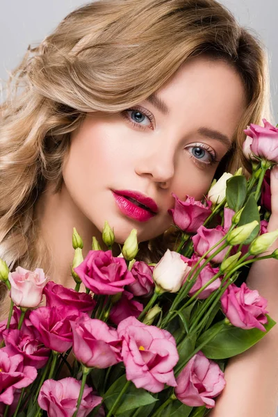 Beautiful blonde woman posing with spring Eustoma flowers bouquet — Stock Photo